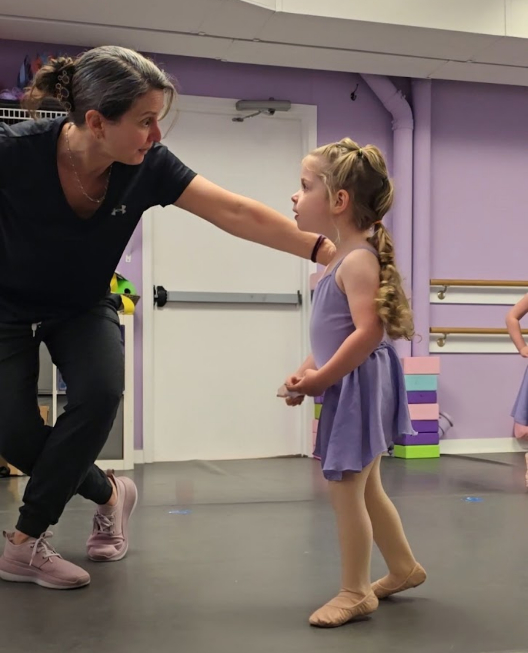 A Dance Connections teacher giving individual attention to a young ballet student